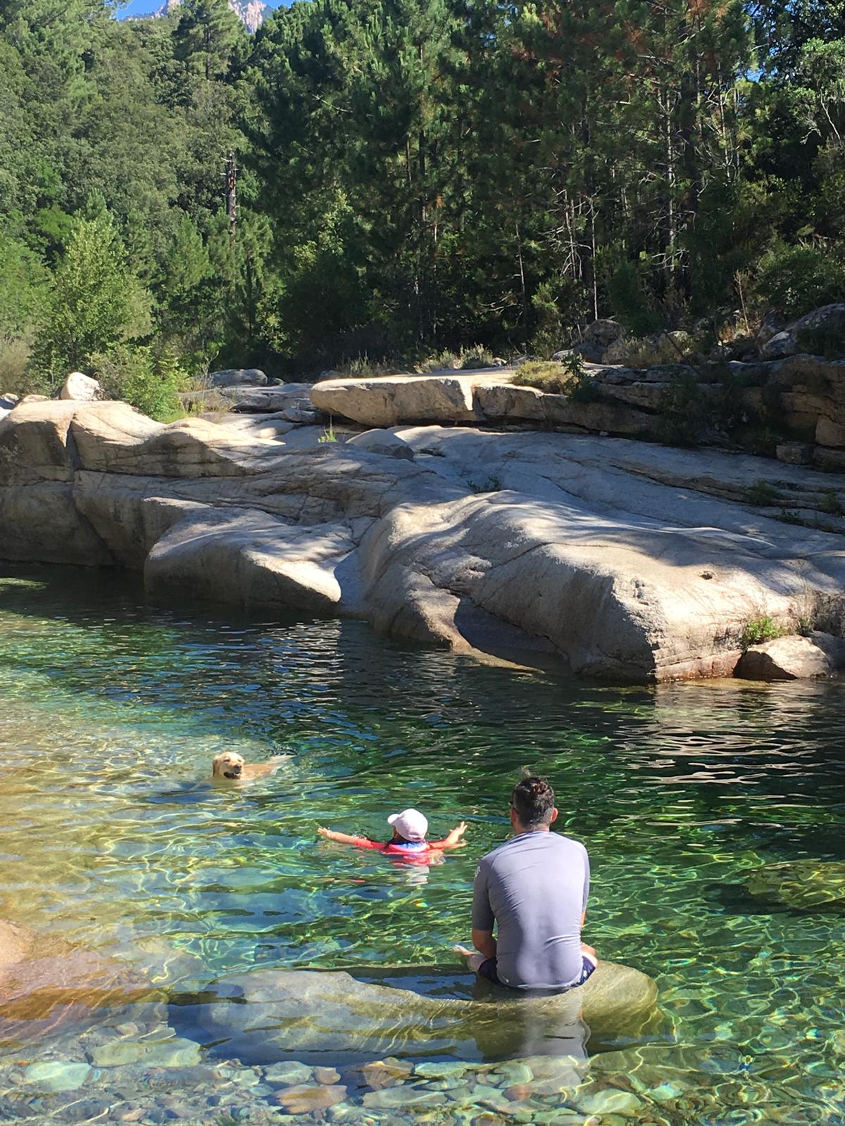 Famille se baignant dans une piscine naturelle en Corse