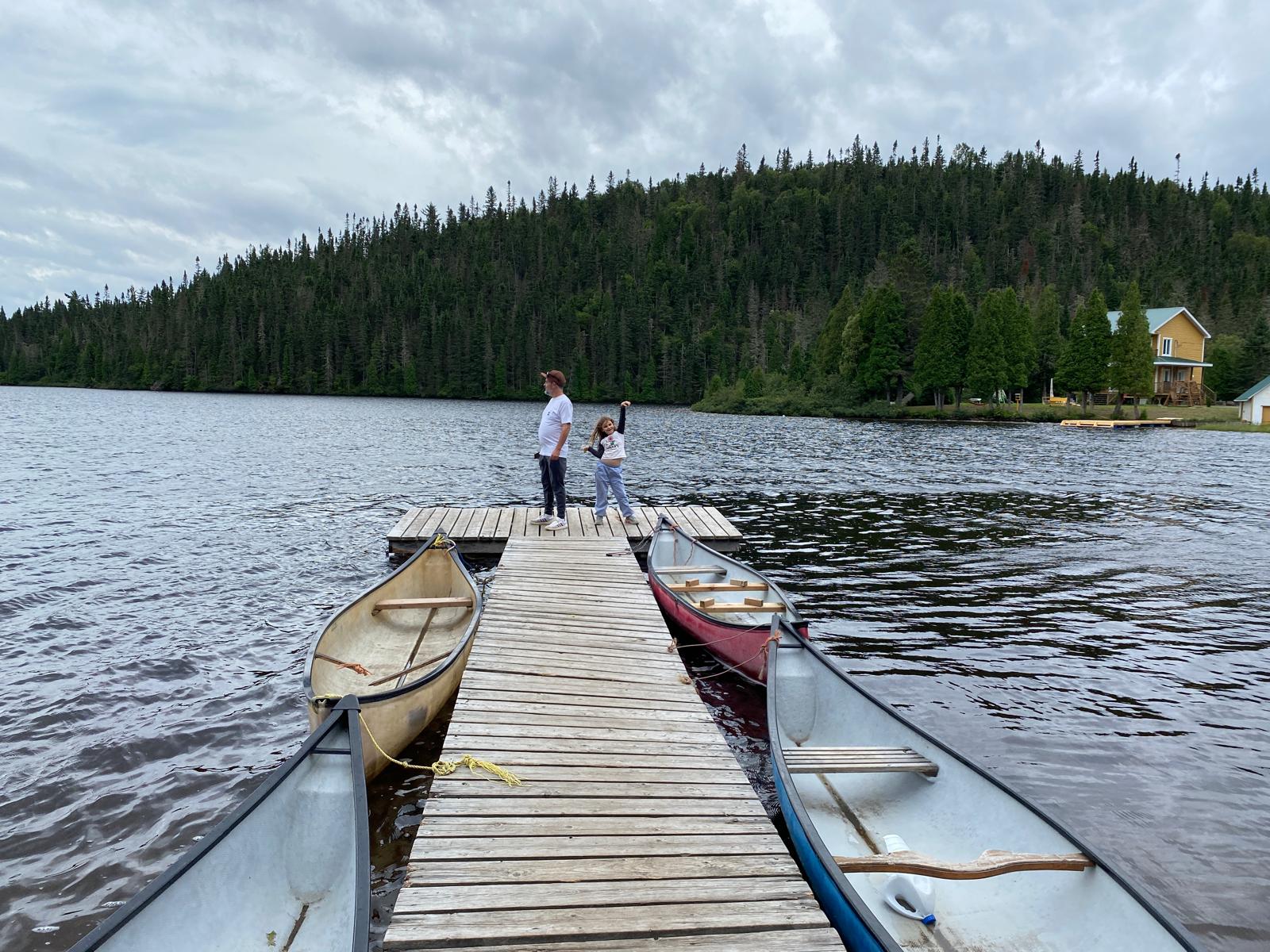 Famille en roadtrip sur le ponton d'un lac au Québec