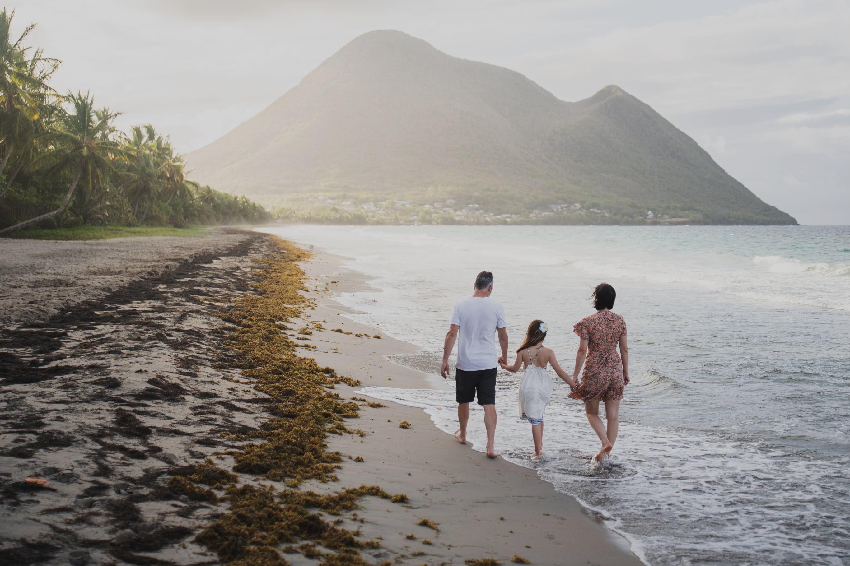 Famille en voyage marchant sur une plage de Guadeloupe - travel planner